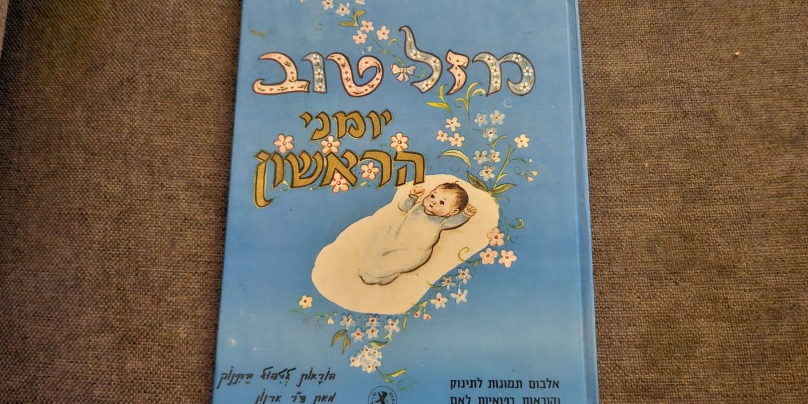 לפני: אלבום תינוק ישן בכריכה כחולה עם פרחים מאוירים